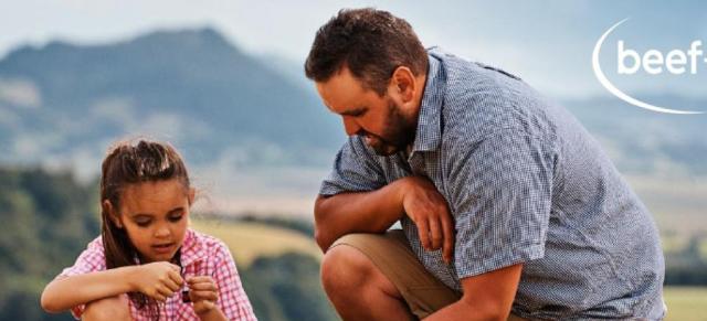 image of father and daughter picking grass on farm