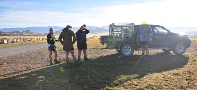 image of three students and mentor next to ute