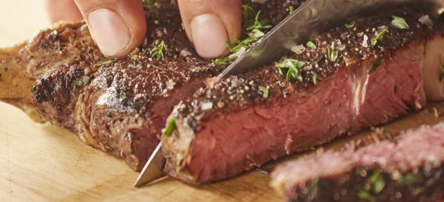 image of person cutting red meat