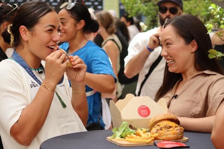 image of stacey wakaa eating lamb burger at olympics