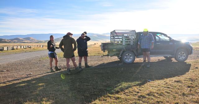 image of three students and mentor next to ute